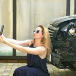 blonde lady taking selfie with car that car accident